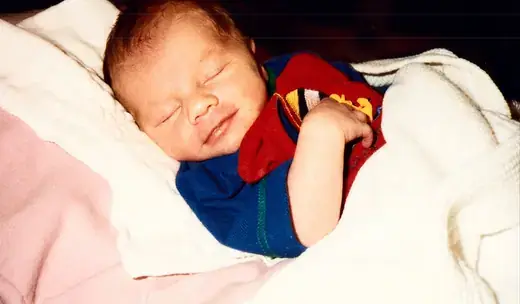 A newborn asleep in a blanket